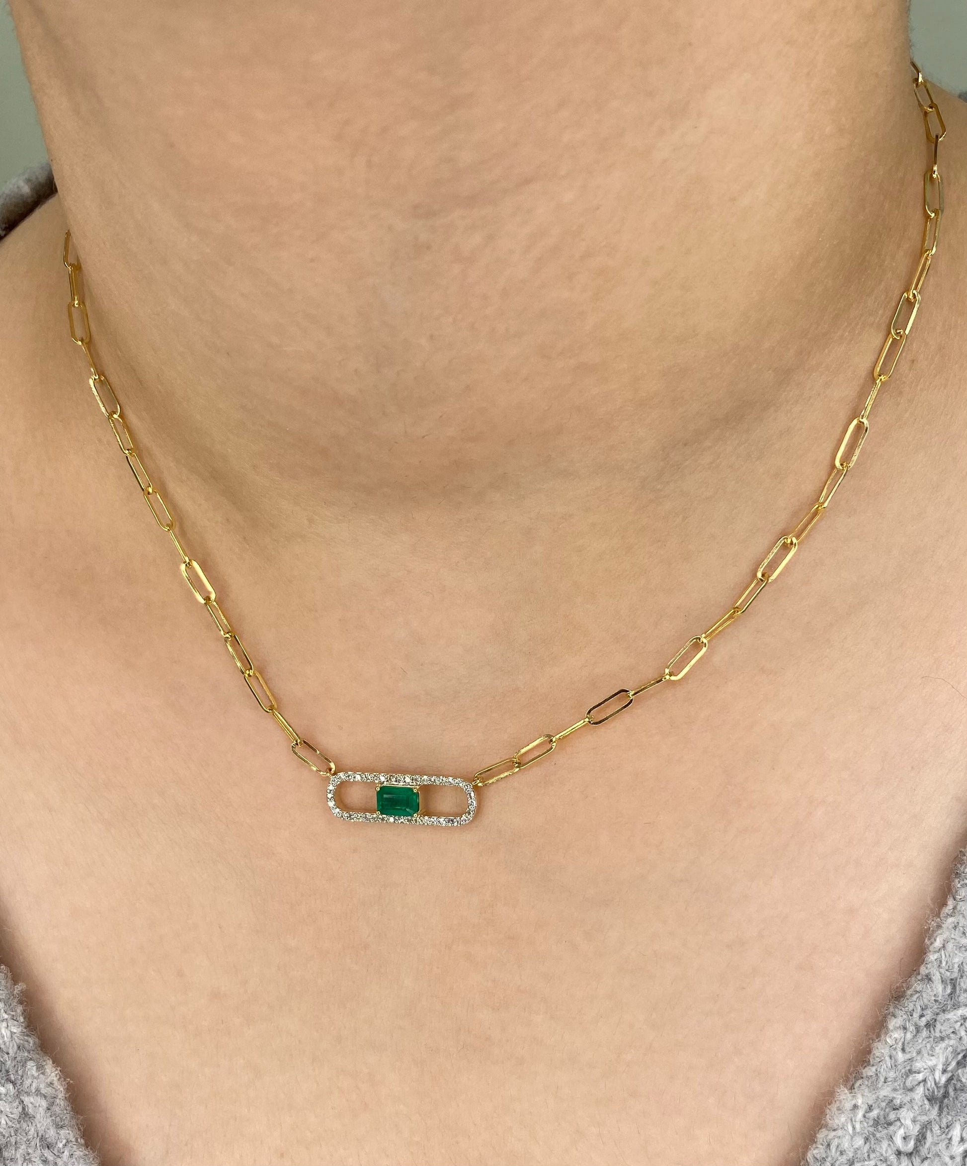 14K Solid Yellow Gold necklace with a green Emerald and diamond gemstone pendant on a white background. Trendy 14K yellow gold Paperclip necklace. 
